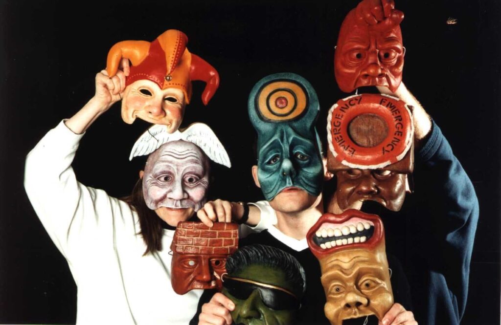 Geese Theatre’s signature mask work. A group of performers in multicoloured, anthropomorphic yet still abstract masks. E.G there is a man with a brick wall for a forehead as well as a more typical harlequin mask.